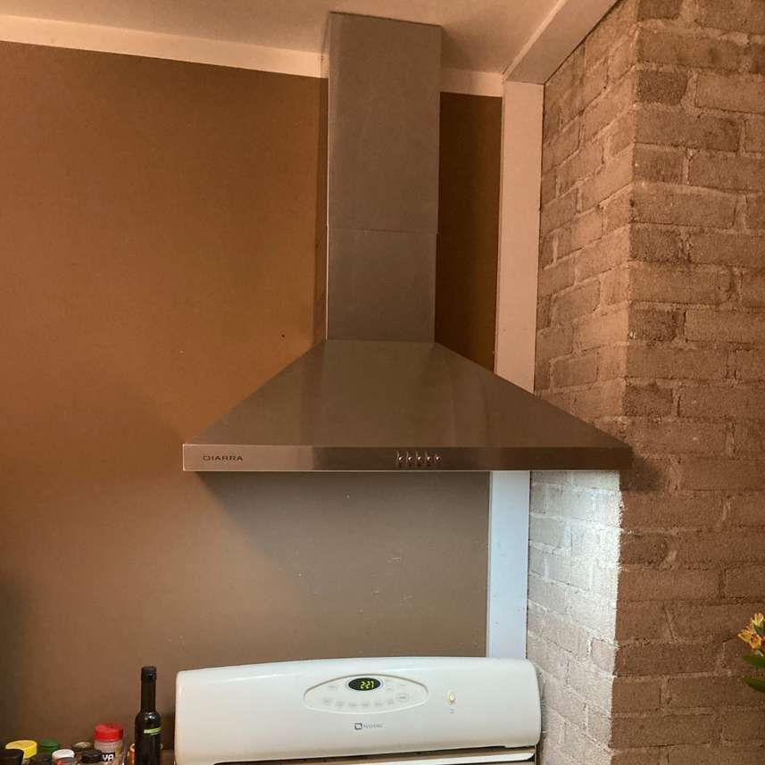 A kitchen with a stove and a hood above it