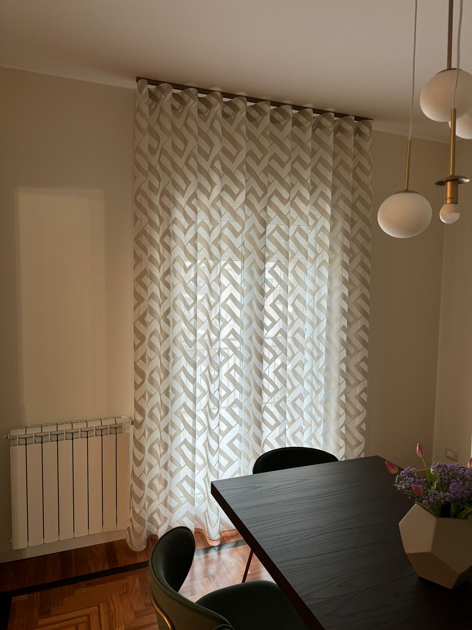 Una sala da pranzo con tavolo, sedie e tende