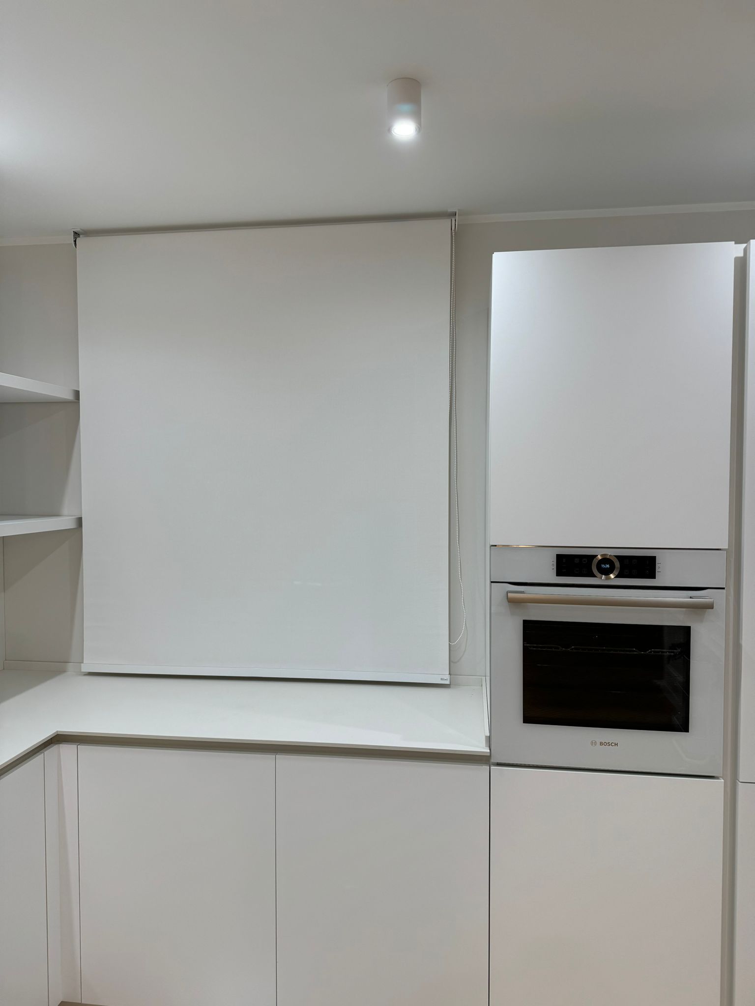 Una cucina con mobili bianchi e un forno nero