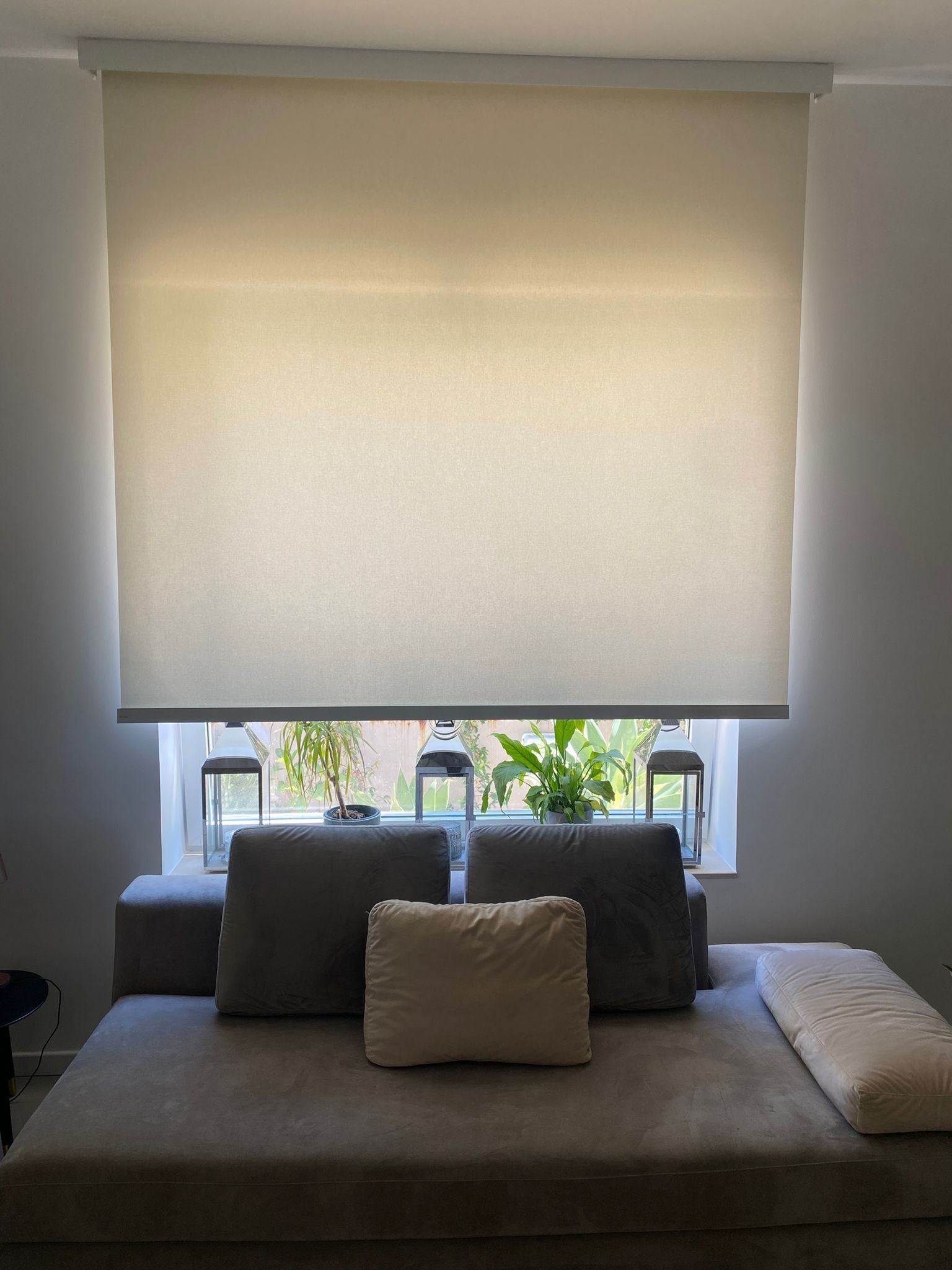 Un soggiorno con un divano e una finestra con le persiane