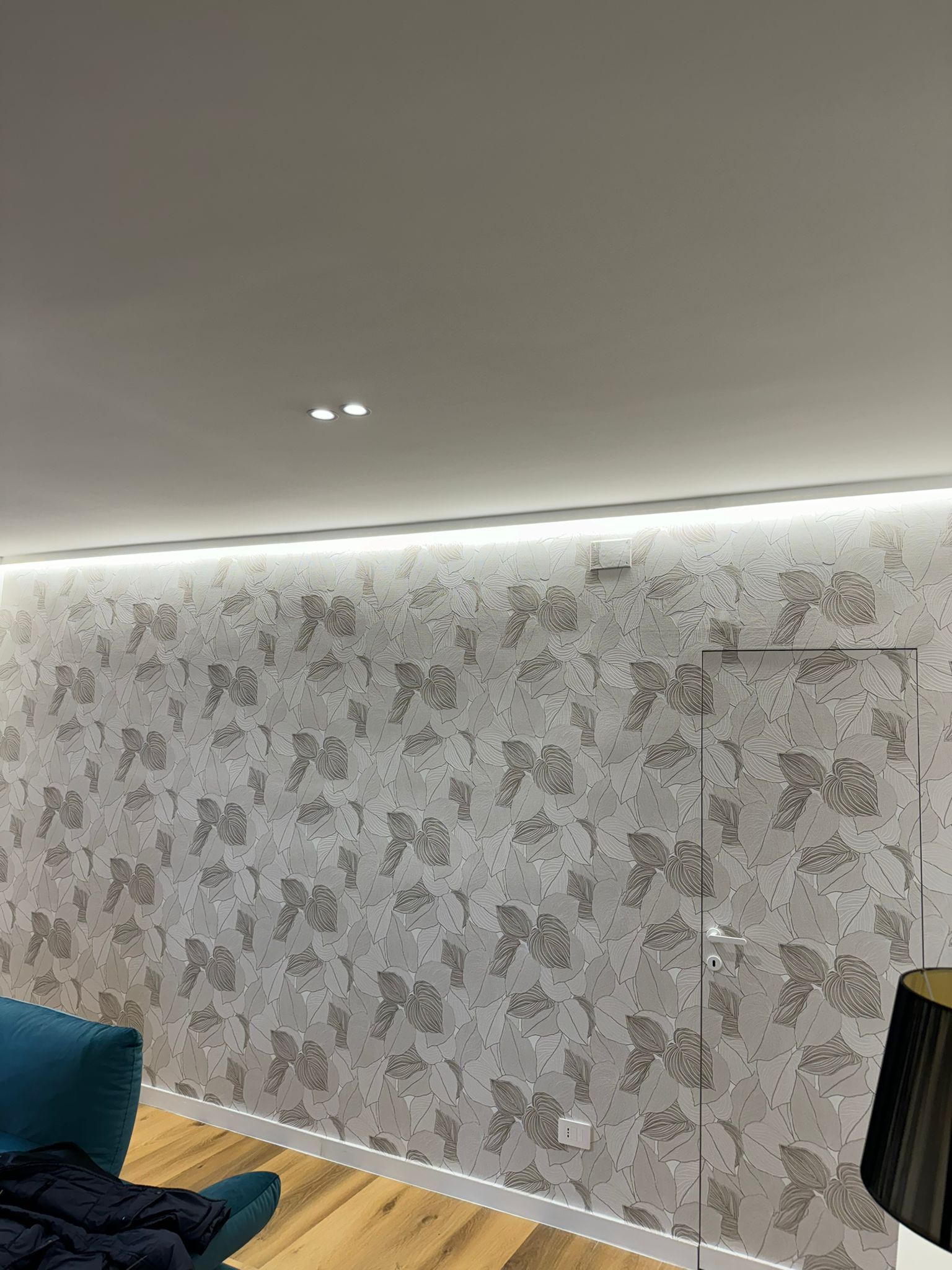 Un soggiorno con un divano, una sedia e una parete decorata con un motivo a farfalle.