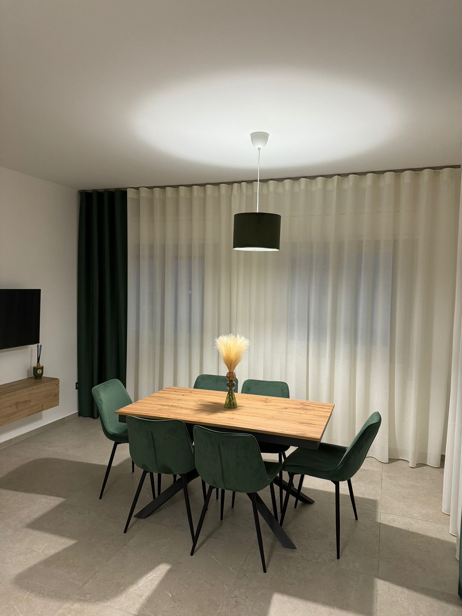 Una sala da pranzo con un tavolo di legno e sedie verdi