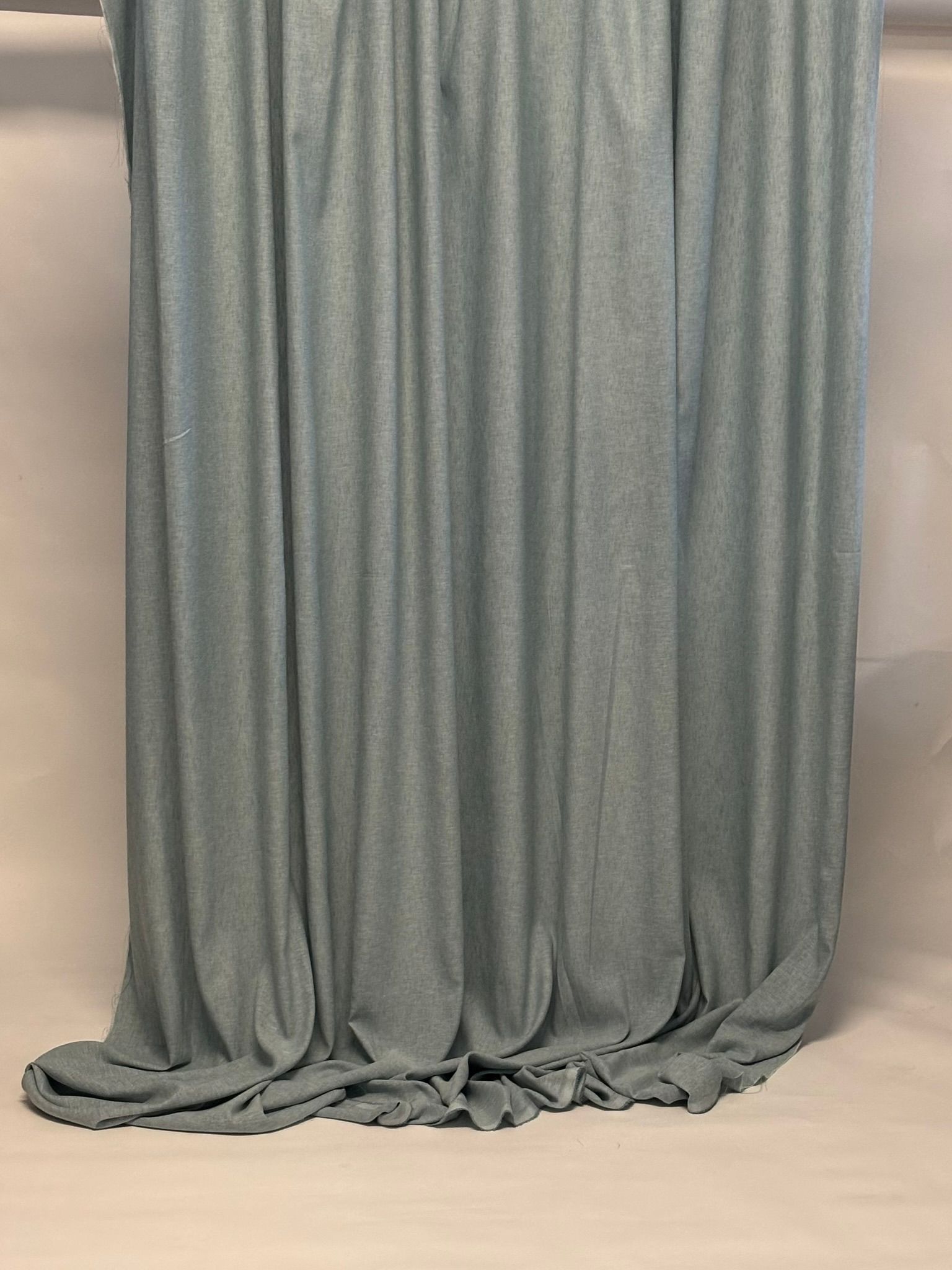 Un primo piano di una tenda grigia appesa a una parete.