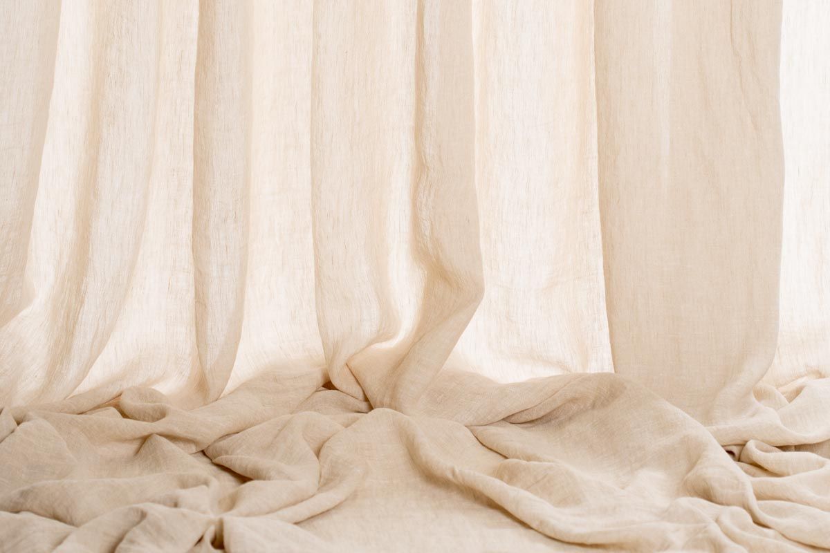 Un primo piano di una tenda bianca appesa a una finestra.