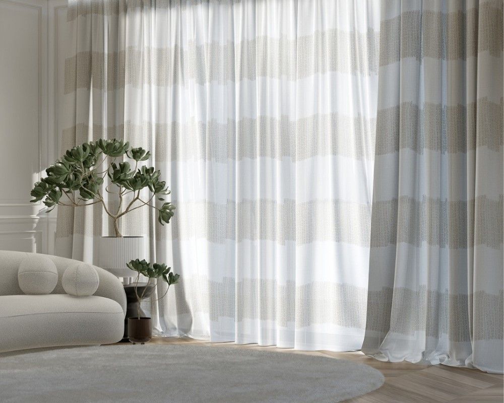 Un soggiorno con divano, tappeto e tende.