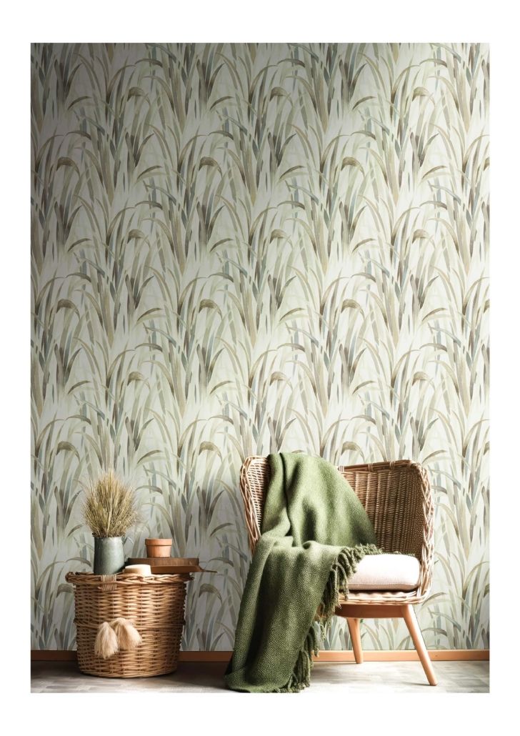 Una sedia con una coperta verde sopra è posta di fronte a una parete con un motivo floreale.