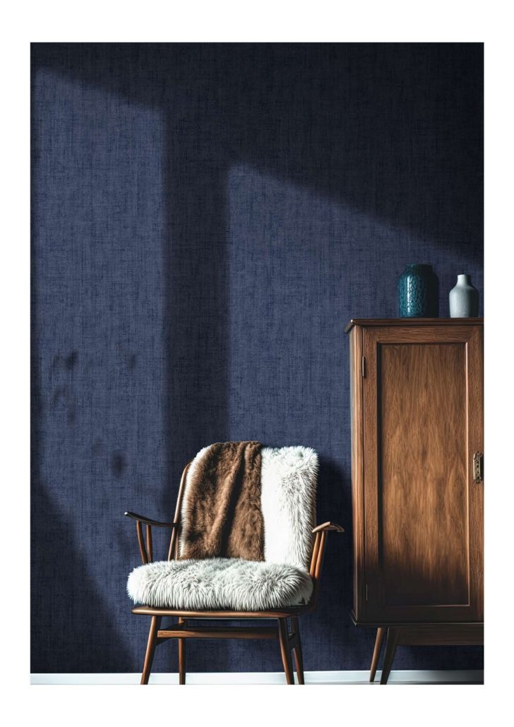 Una sedia con una coperta sopra è posta di fronte a un muro blu scuro.