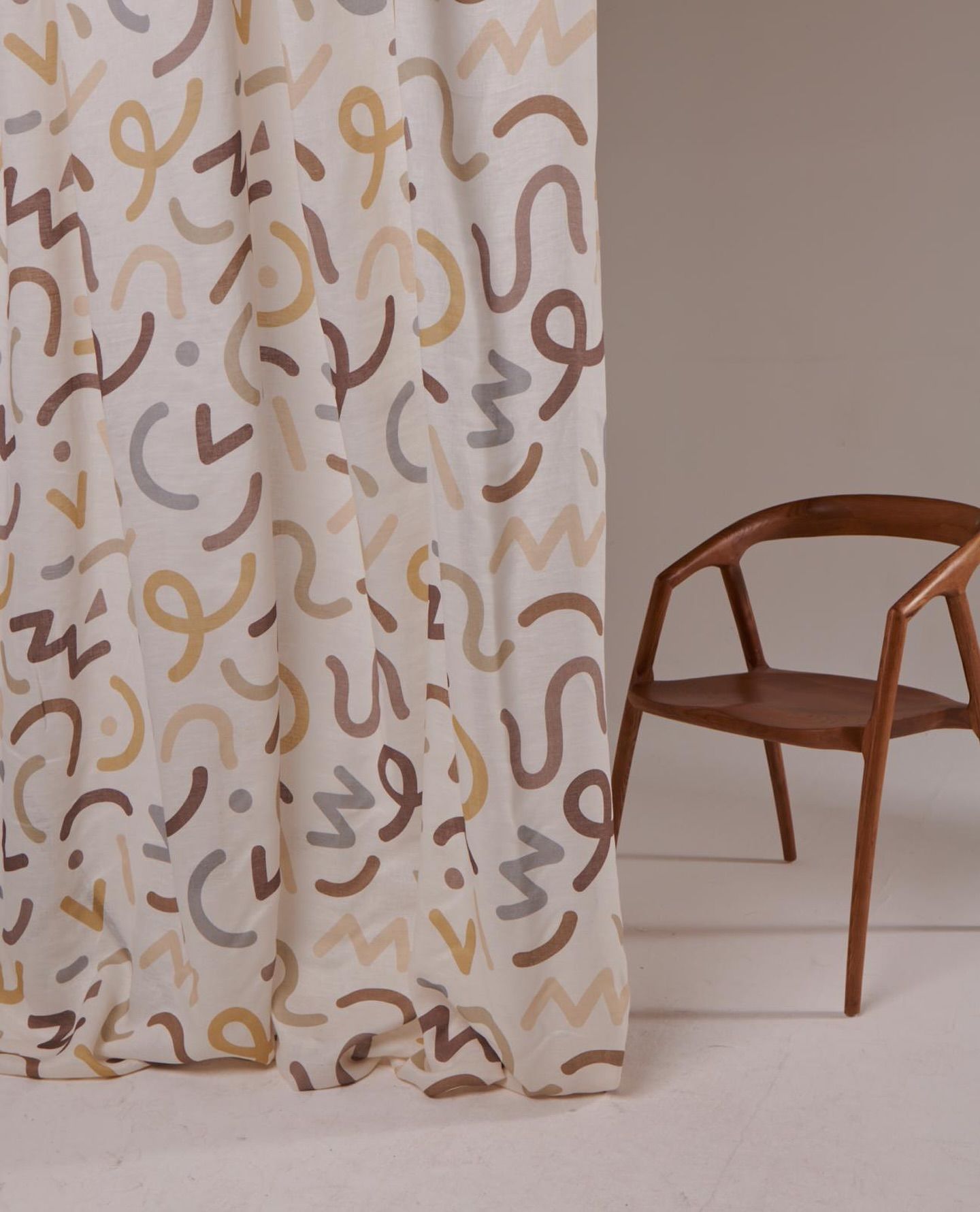 Una sedia è appoggiata accanto a una tenda su cui c'è scritto s