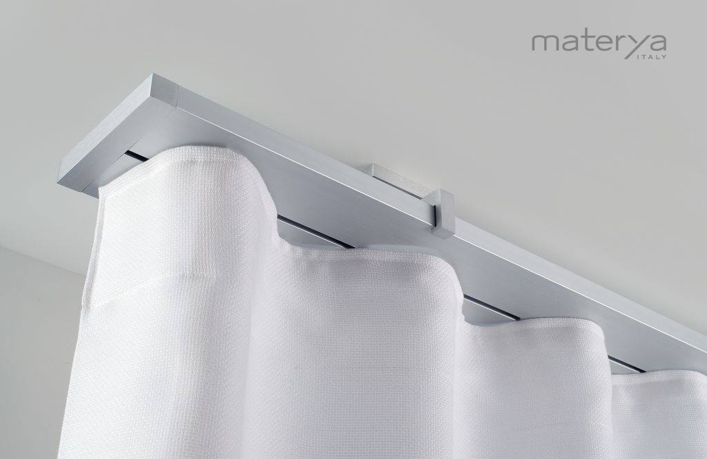 Una tenda bianca è appesa a un soffitto bianco.