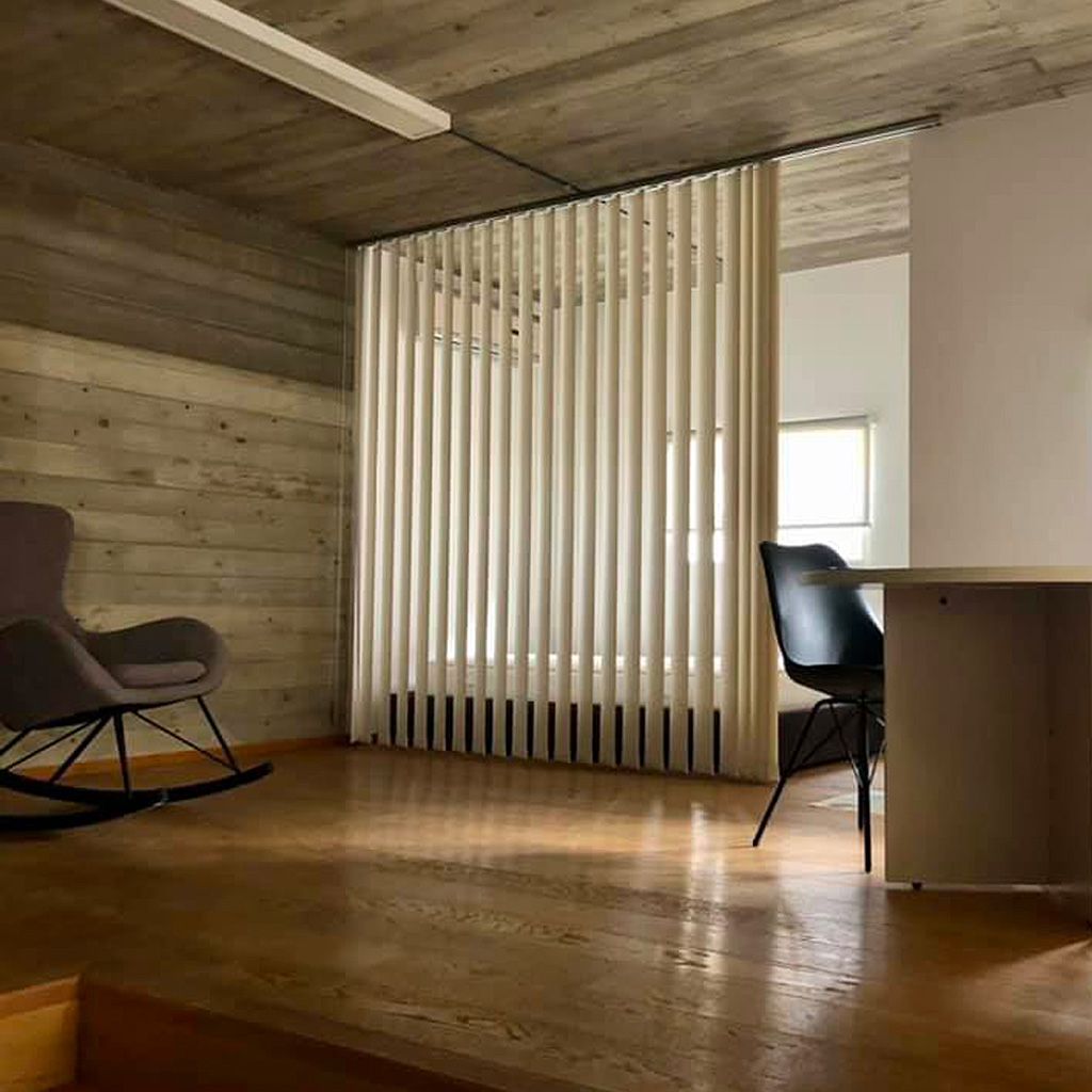 Un soggiorno con una sedia a dondolo e una scrivania.