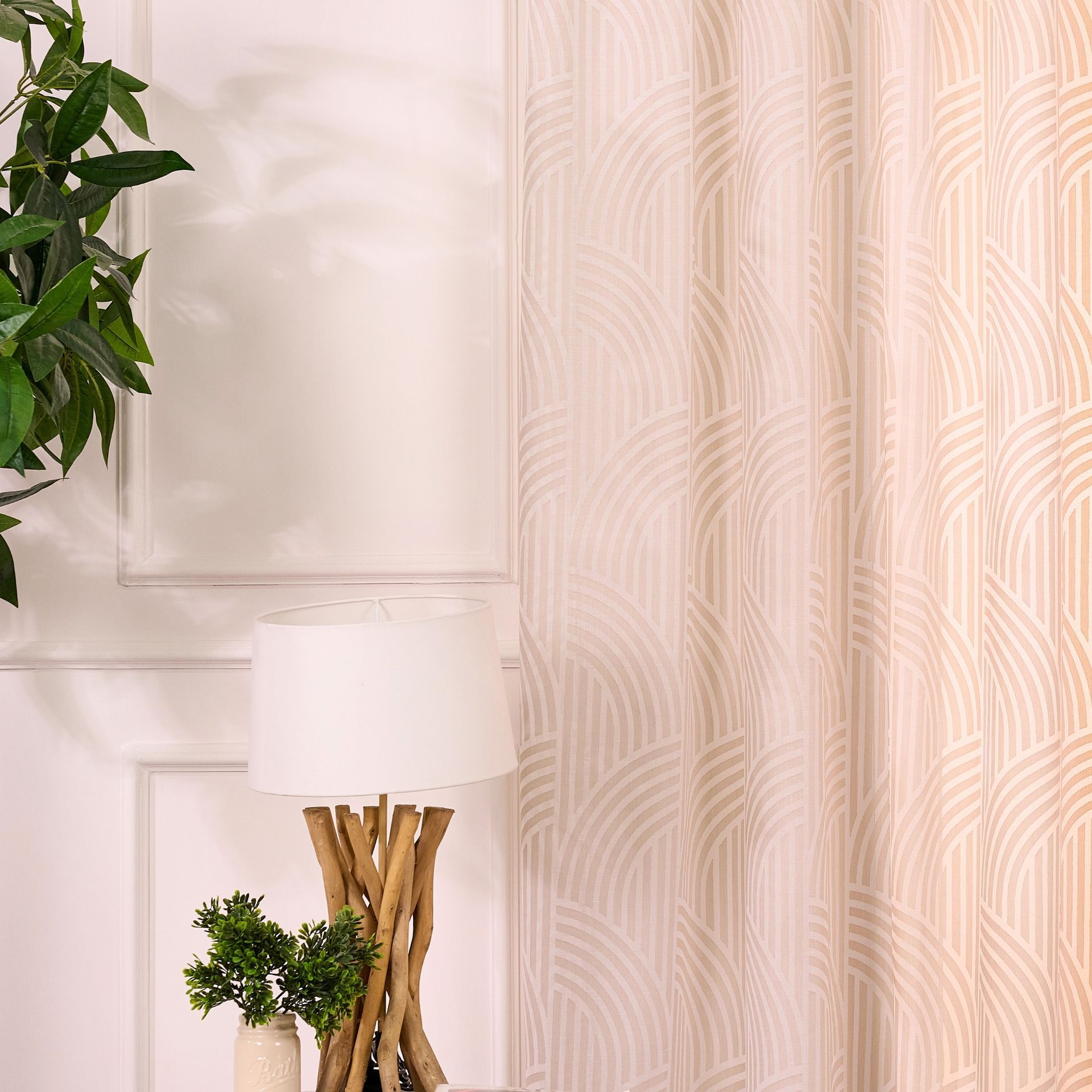 Una lampada è appoggiata su un tavolo accanto a una pianta.