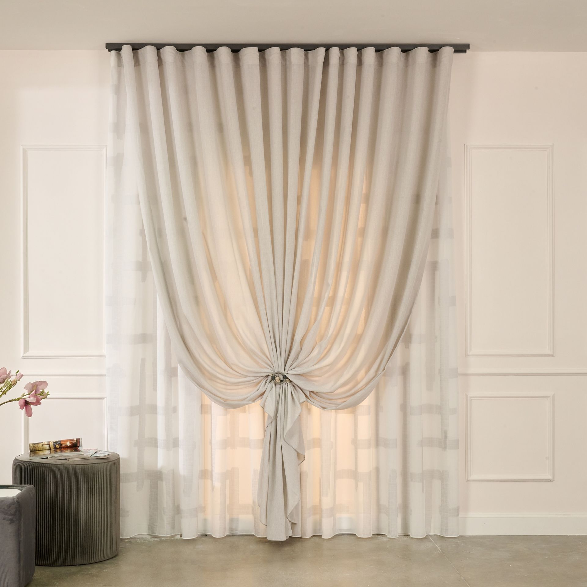 Un paio di tende bianche sono appese a una finestra in un soggiorno.