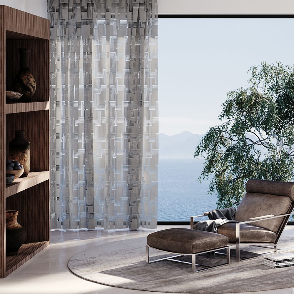 Un soggiorno con una sedia e un pouf e una grande finestra con vista sull'oceano