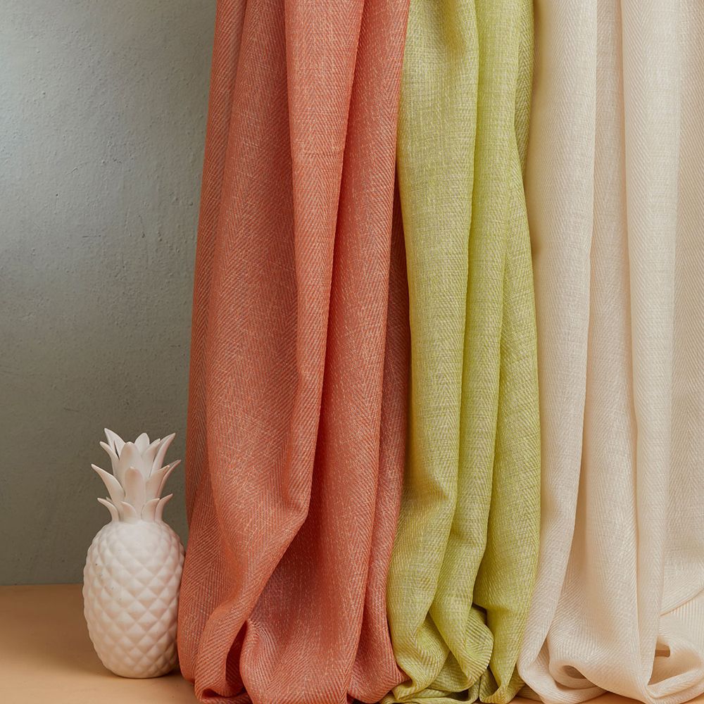 Un ananas è appoggiato accanto a un mucchio di tende su un tavolo.