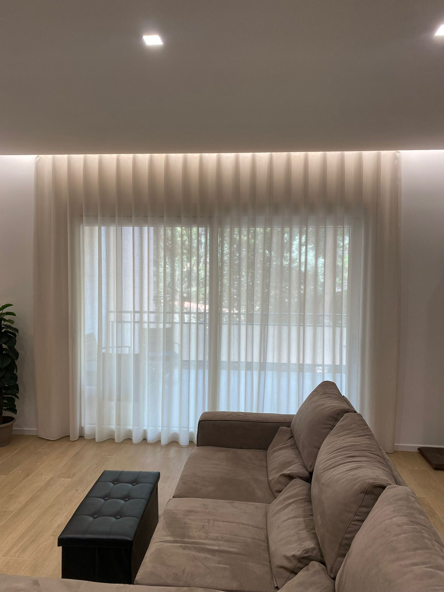 Un soggiorno con divano, tavolo e tende.