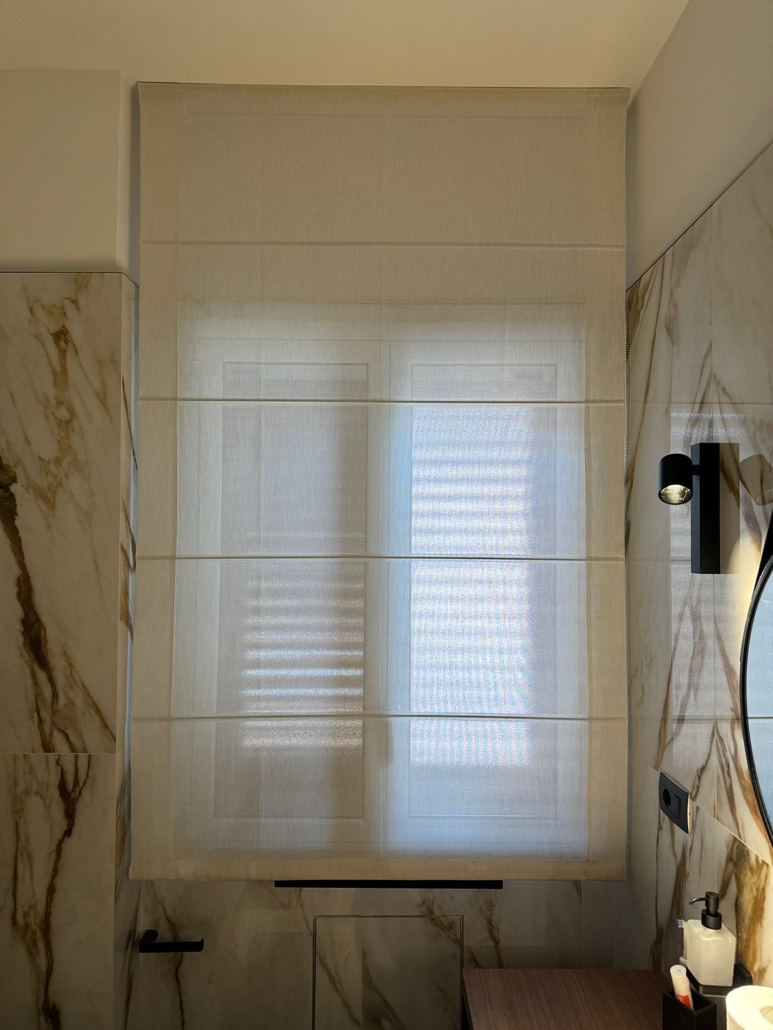 Un bagno con una finestra con una tenda.