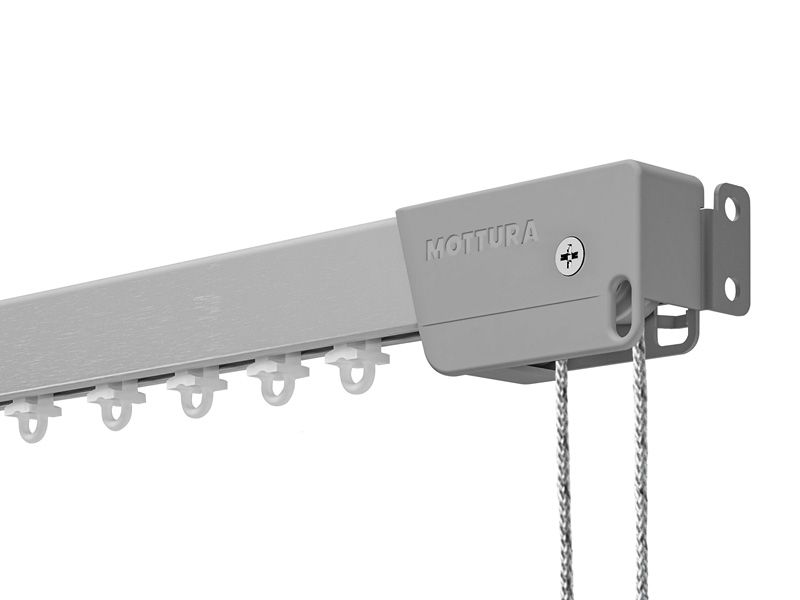 Primo piano di un binario per tende con ganci e catene su sfondo bianco.