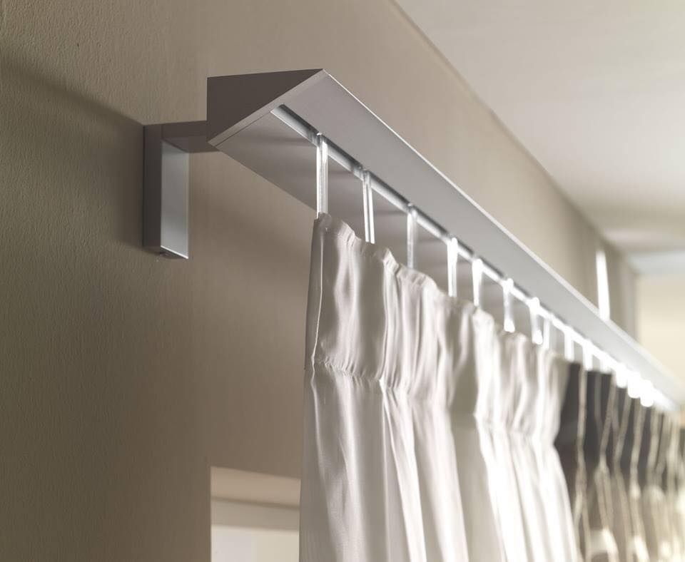 Una tenda bianca è appesa a una ringhiera bianca