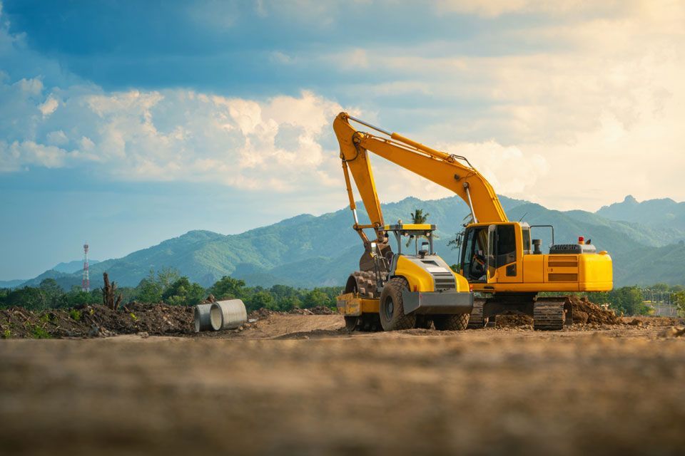 A Yellow Excavator is Working on a Construction Site | Round Lake, IL | Korinek & Son Concrete and Asphalt