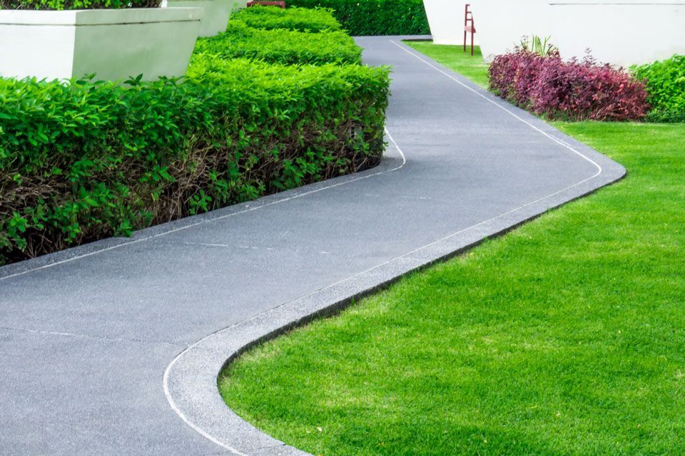 A Curved Driveway Leading to a House With a Lush Green Lawn | Round Lake, IL | Korinek & Son Concrete and Asphalt