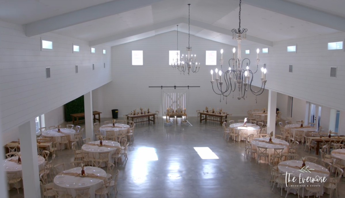 A large room filled with tables and chairs and a chandelier.