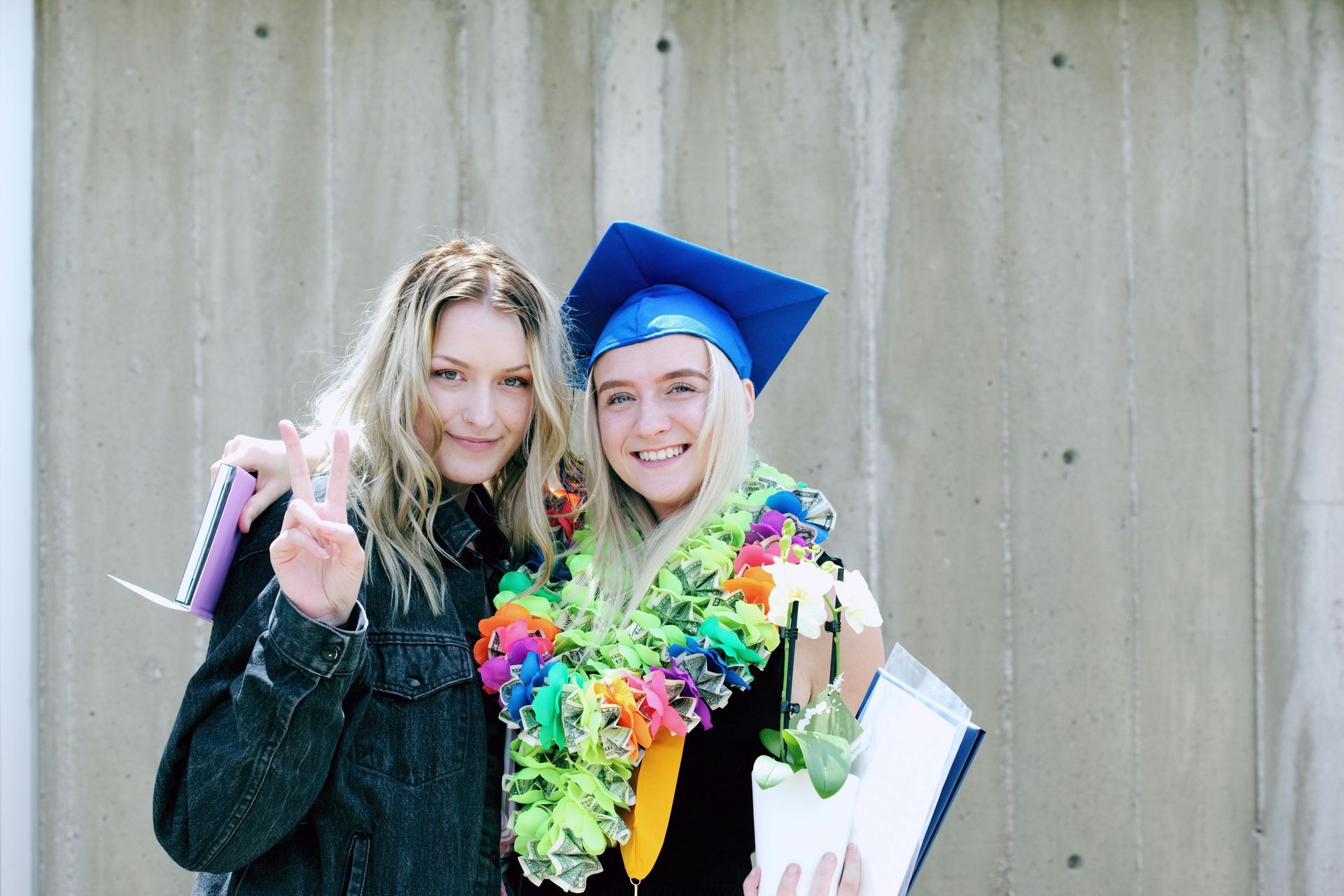 Two women in graduation caps and gowns are posing for a picture.