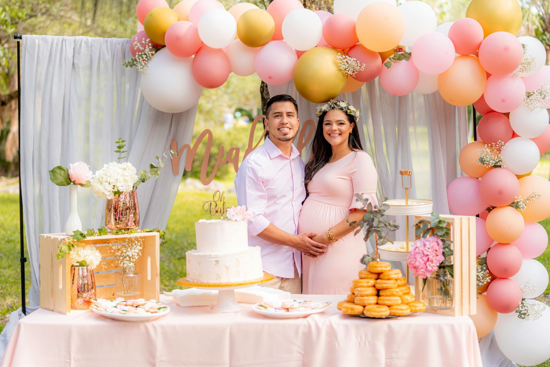 A pregnant woman and a man are posing for a picture at a baby shower.