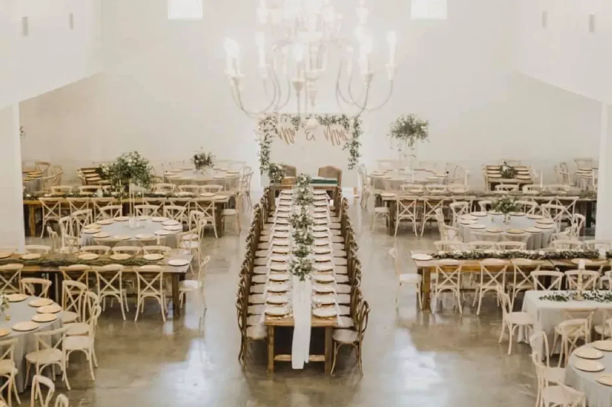 A large room filled with tables and chairs for a wedding reception.