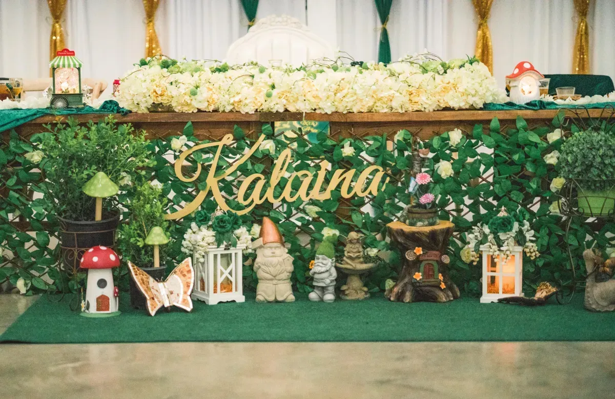 A table with flowers and gnomes on it and a sign that says katrina.