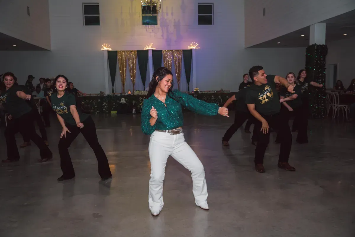 A group of people are dancing in a room.