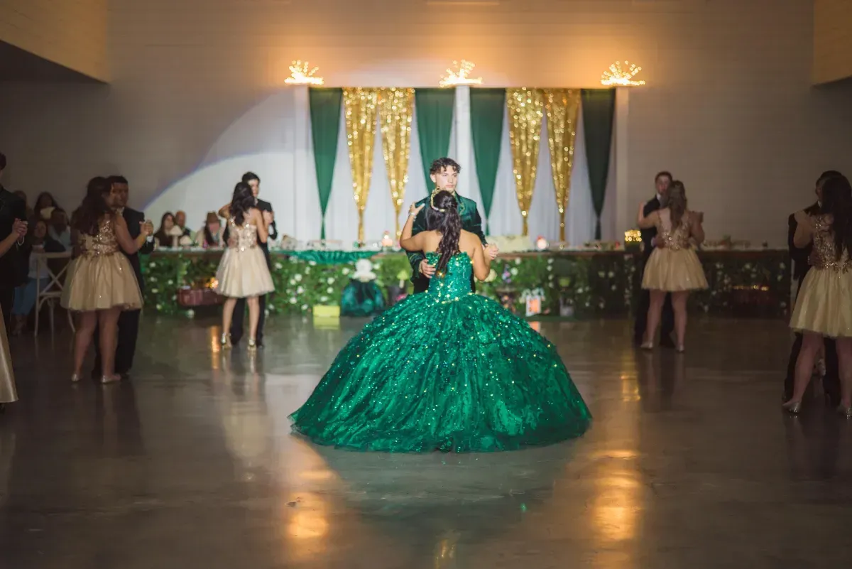 A woman in a green dress is dancing on a dance floor.