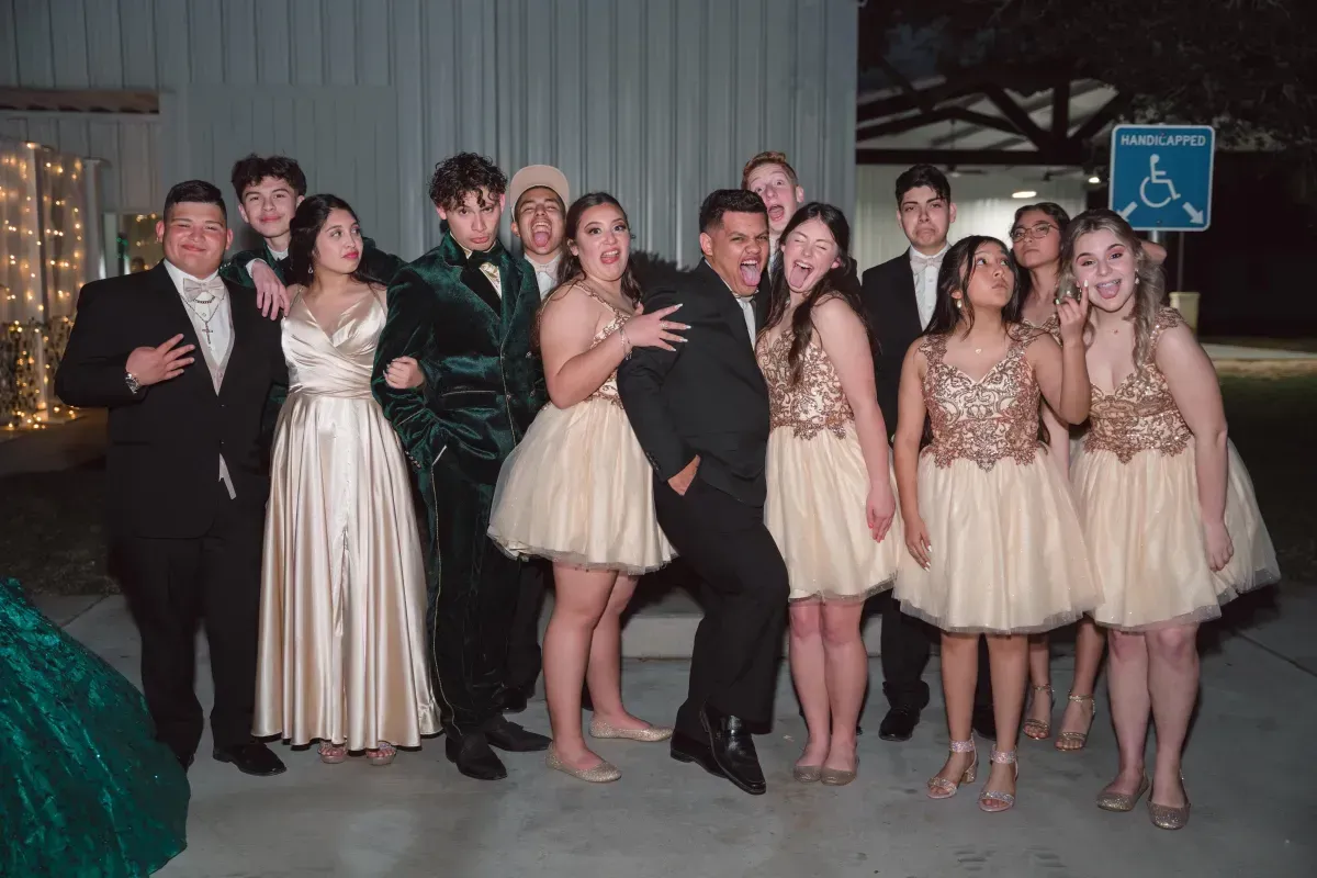 A group of people are posing for a picture in front of a handicap sign.