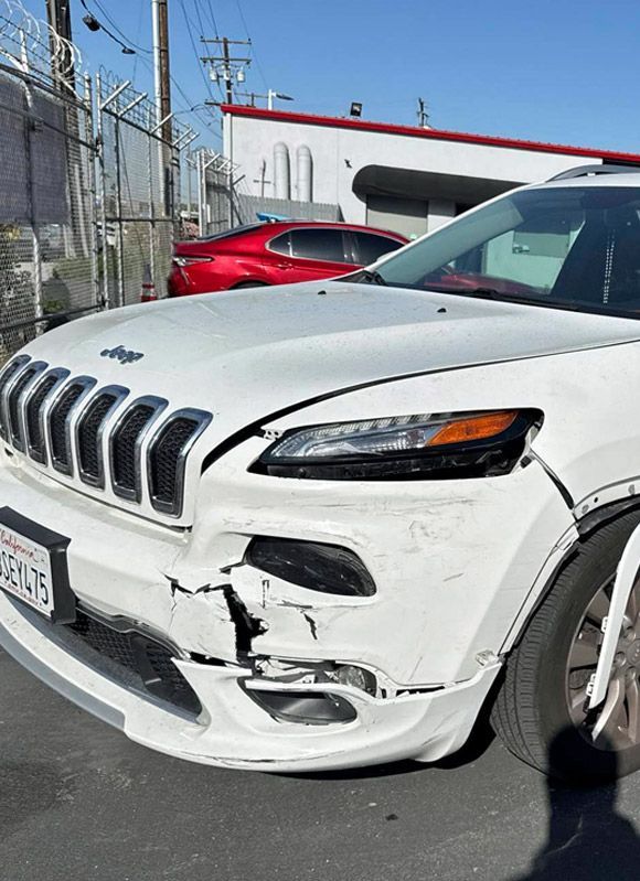 Jeep front fender damage after a collision.