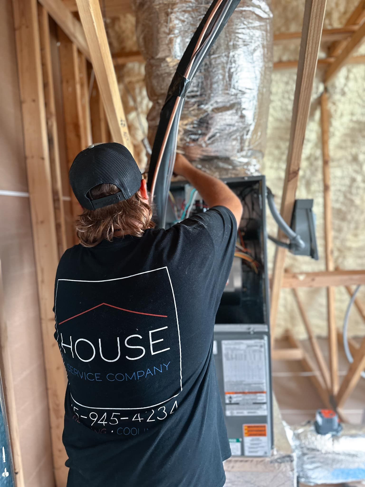 A man wearing a black shirt with the word house on it