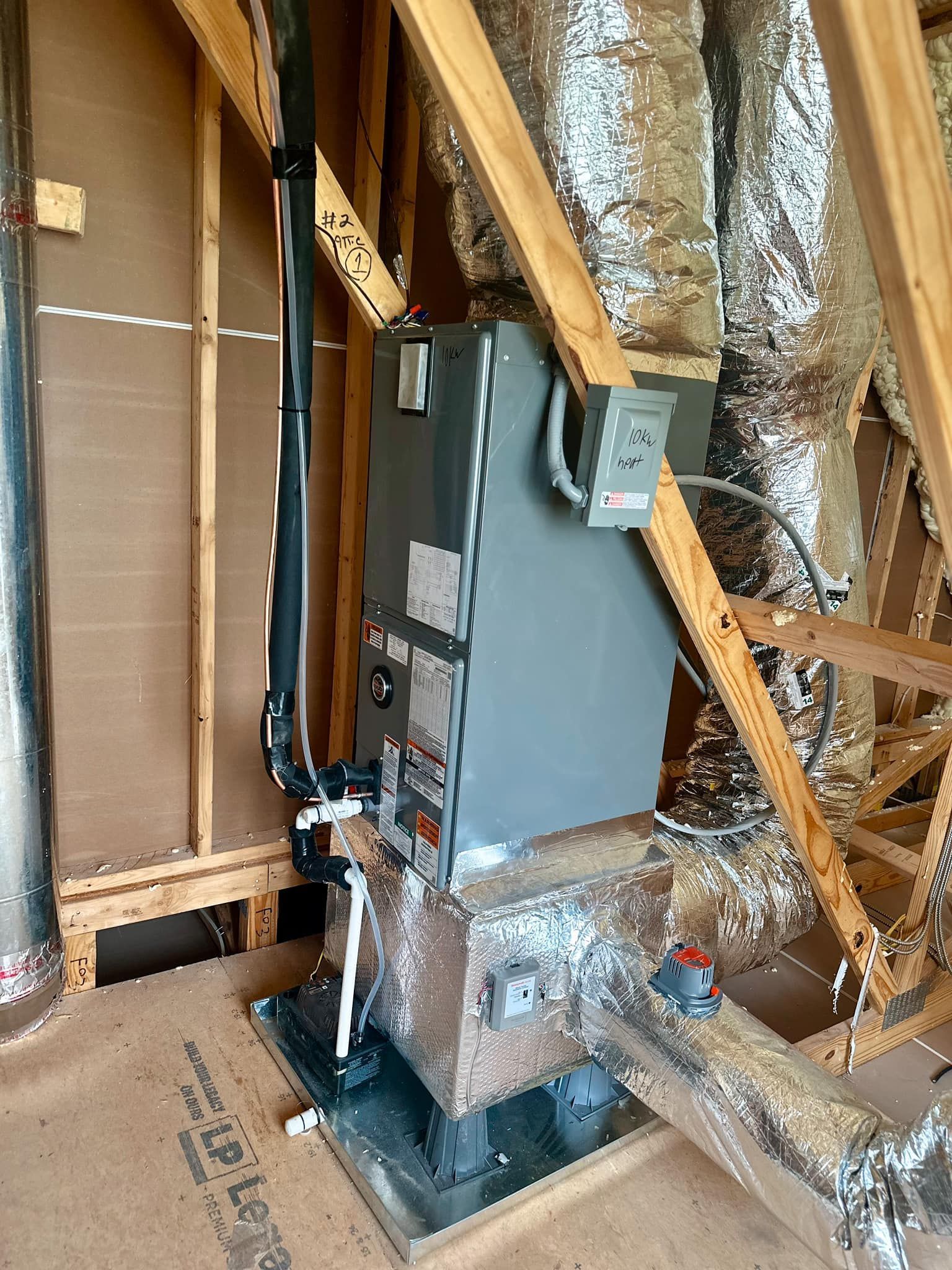 An air conditioner is sitting in the attic of a house under construction