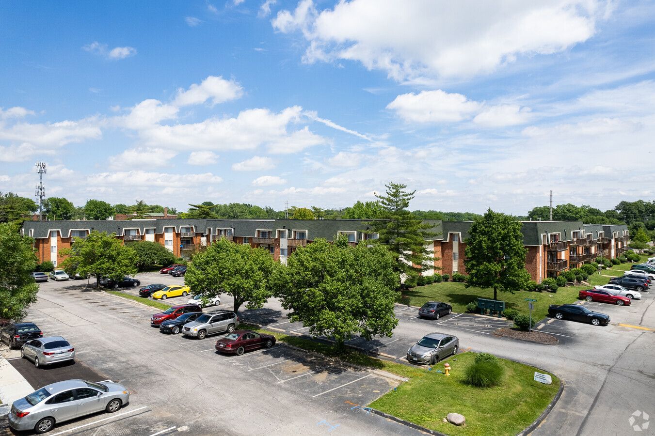 An aerial view of a parking lot with cars parked in front of a building.