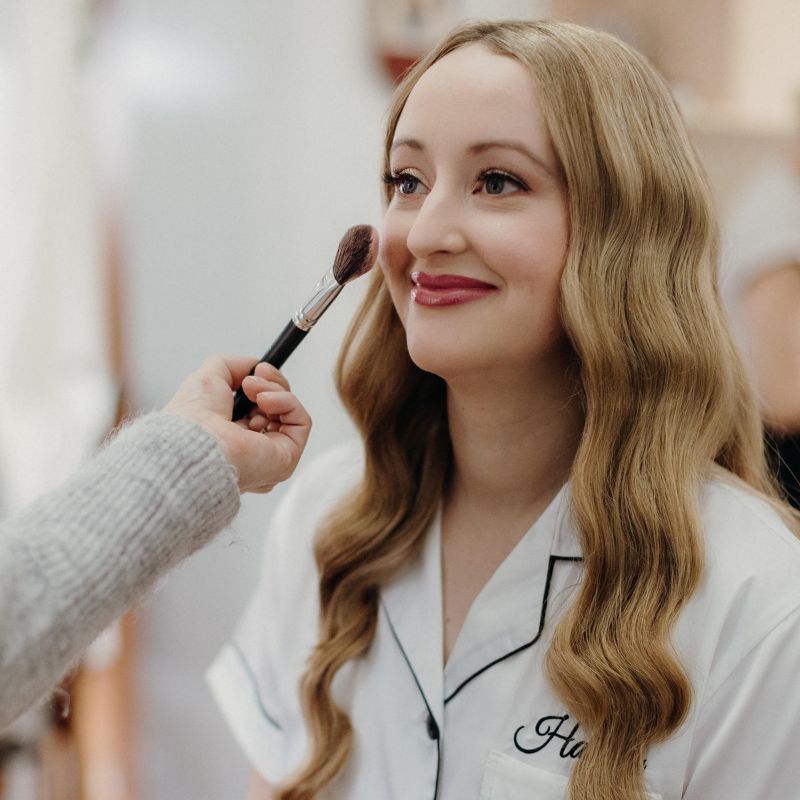 bride having her makeup put on before her wedding