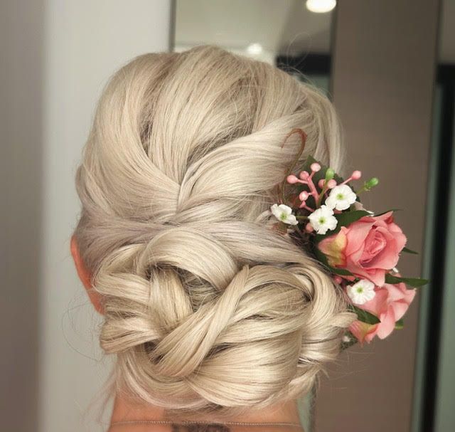 A woman with blonde curly hair in a bun