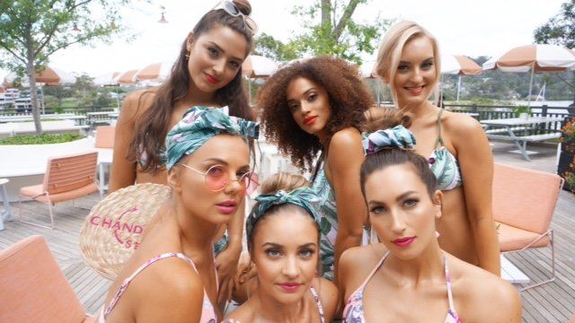 A group of women in bikinis are posing for a picture.