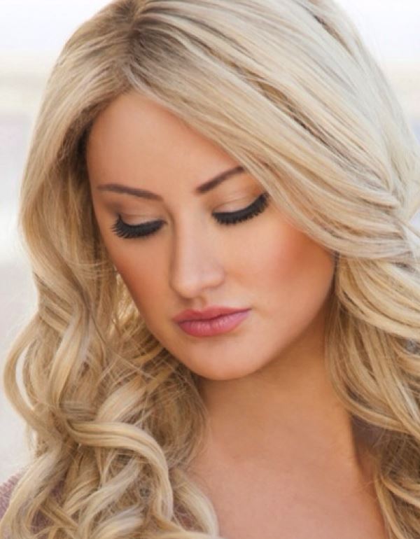 A close up of a woman 's face with her eyes closed.