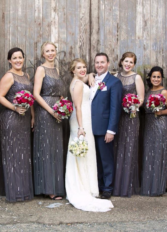 A bride and groom pose for a picture with their bridesmaids