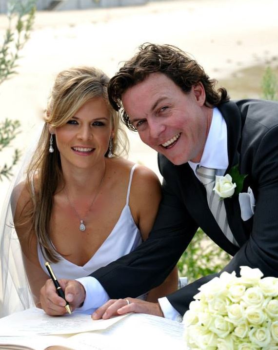 A bride and groom are signing a book together