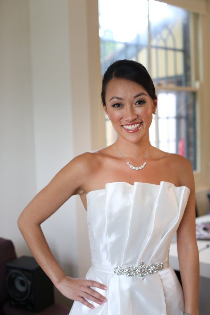 A woman in a white strapless dress smiles for the camera