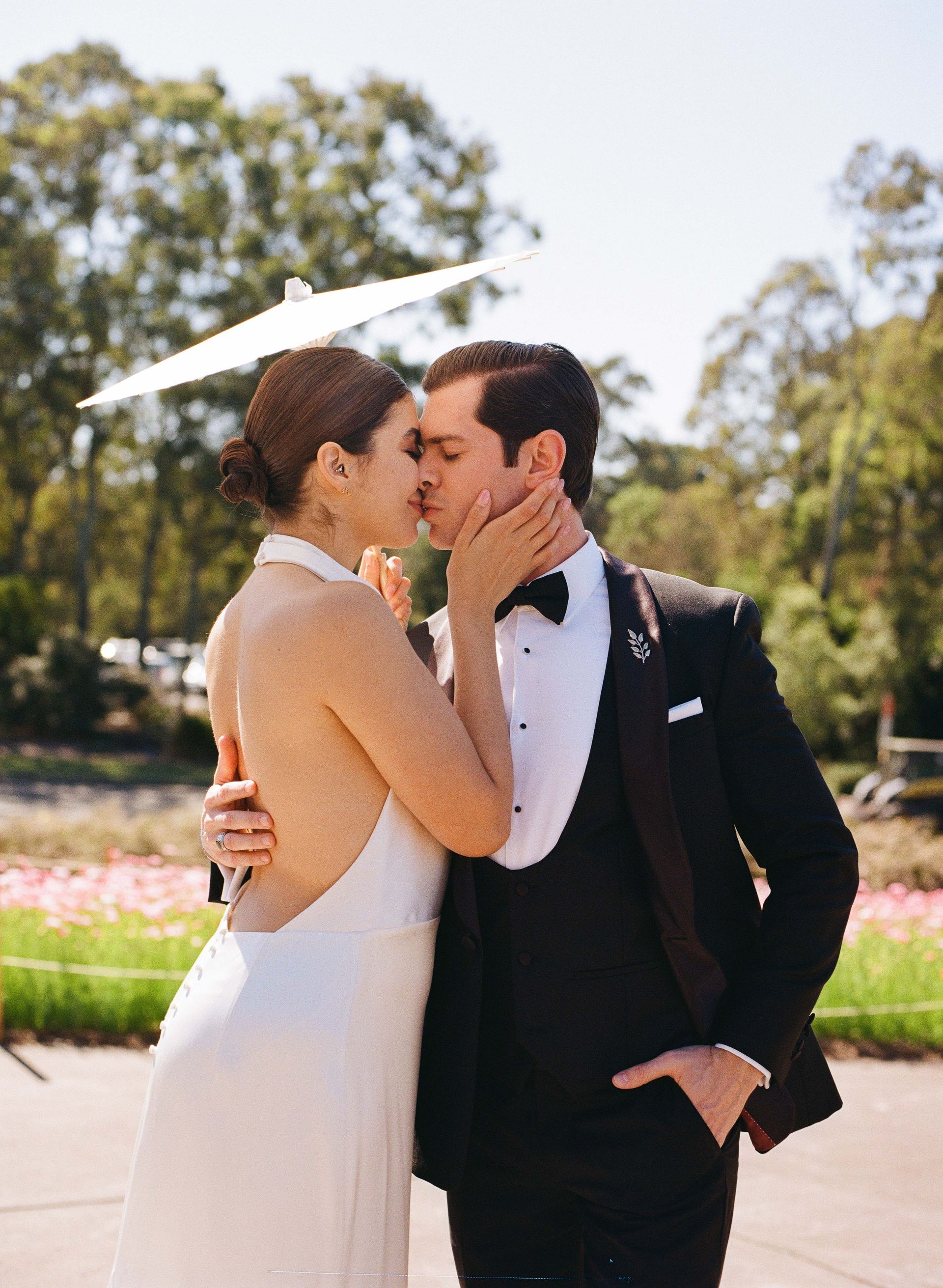 bride kisses her groom after having hair and makeup done