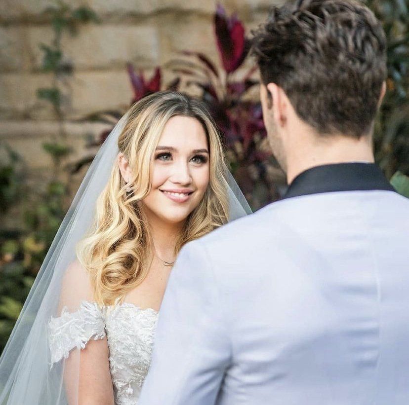 A bride and groom are looking at each other on their wedding day.