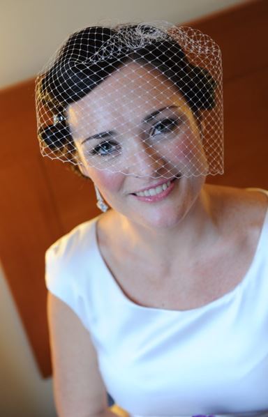 A woman wearing a veil is smiling for the camera