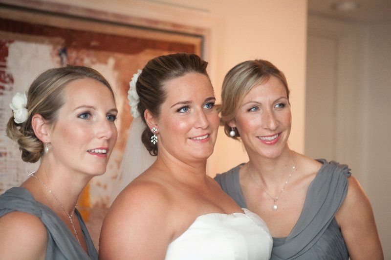 A bride and her two bridesmaids are posing for a picture