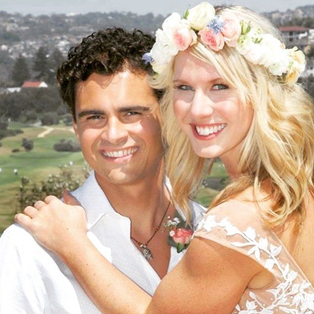 A man and a woman posing for a picture with the woman wearing a flower crown