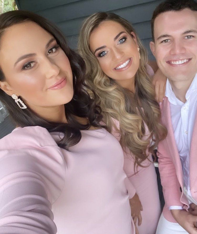 Two women and a man are posing for a picture together