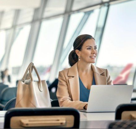 A woman is sitting at a table using a laptop computer